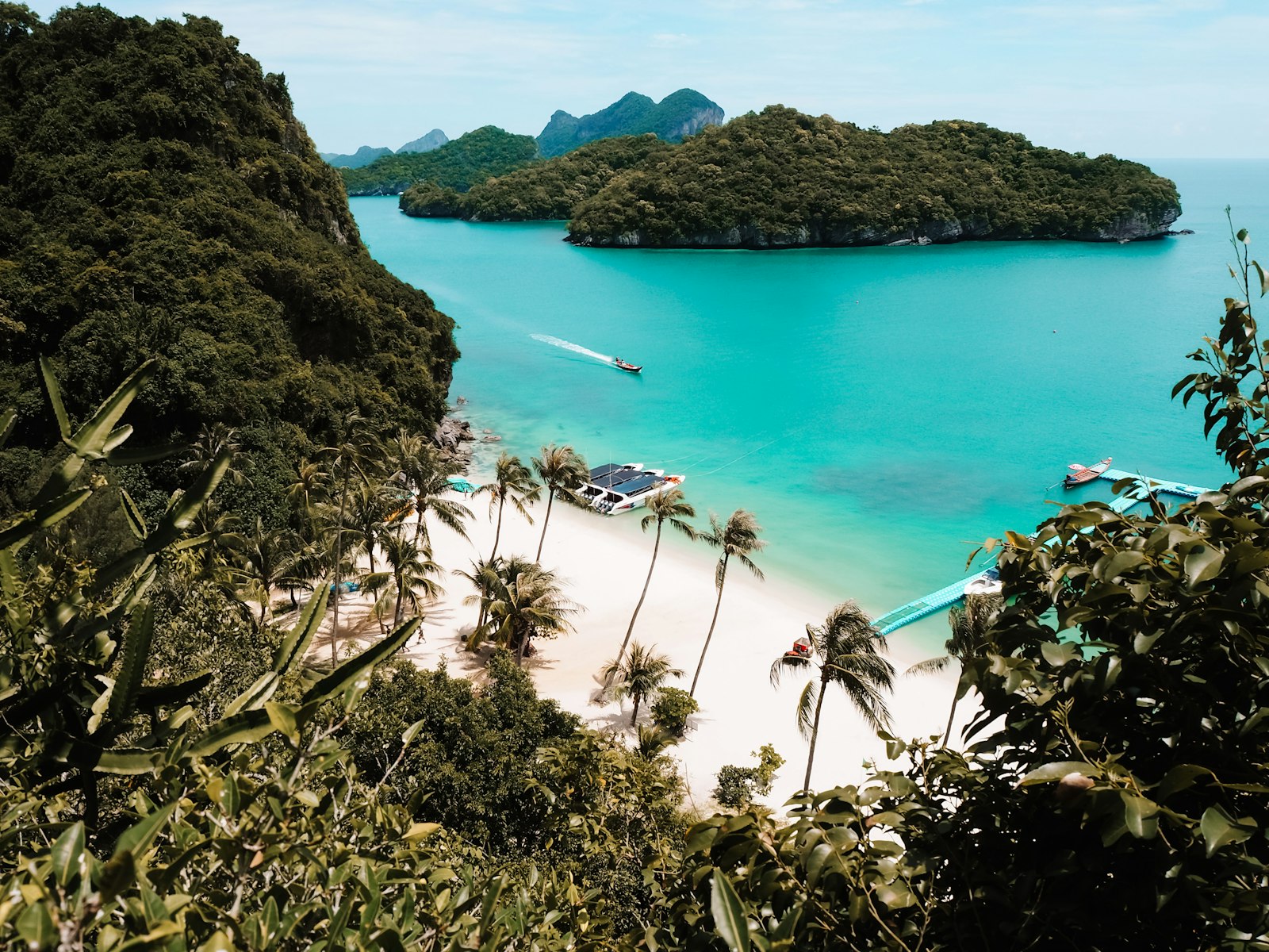 A quiet white-sand bay inside Ang Thong National Marine Park with longtail boats in turquoise water